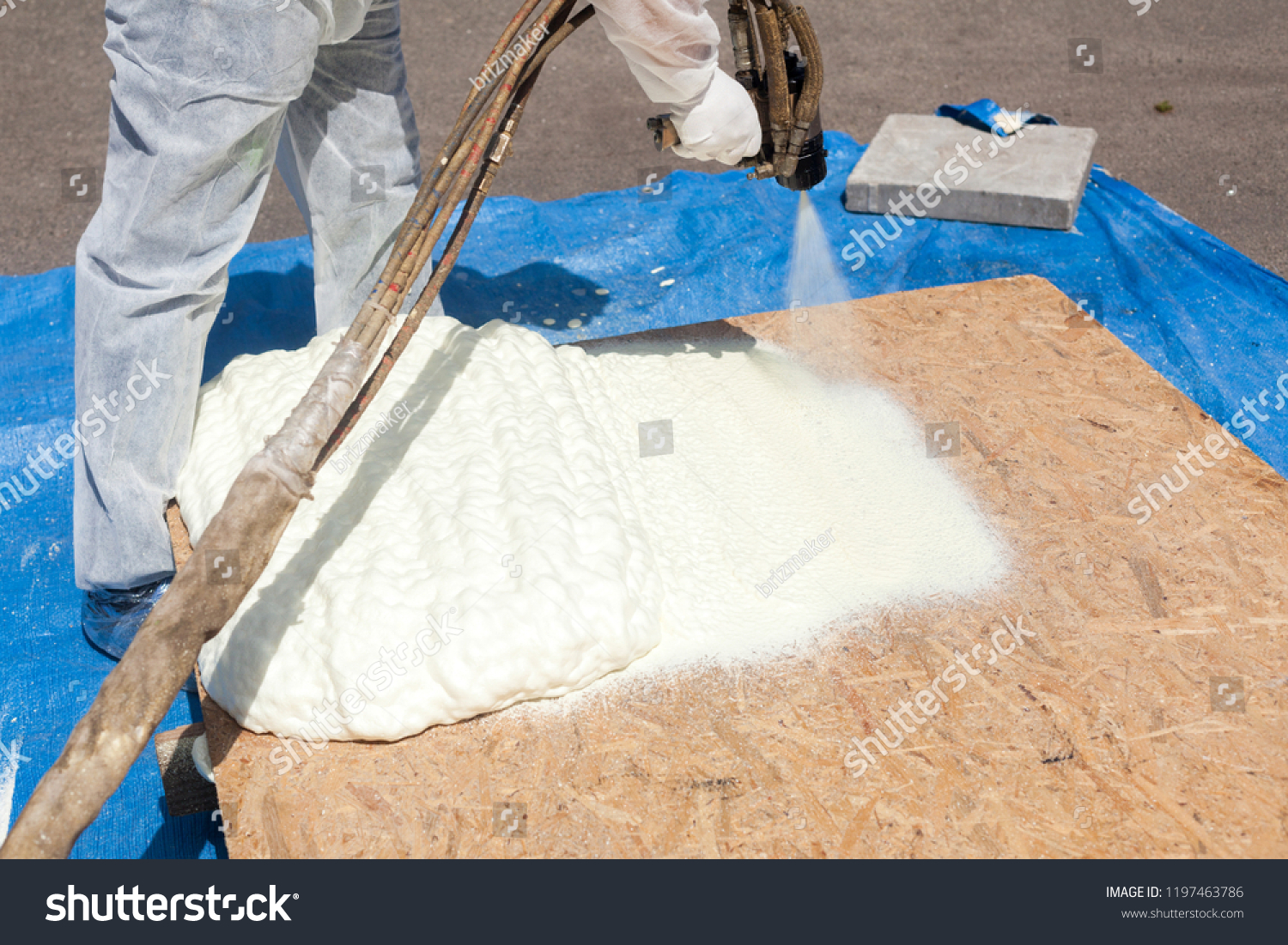 stock-photo-close-up-view-of-technician-dressed-in-a-protective-white-uniform-spraying-foam-insulation-using-1197463786
