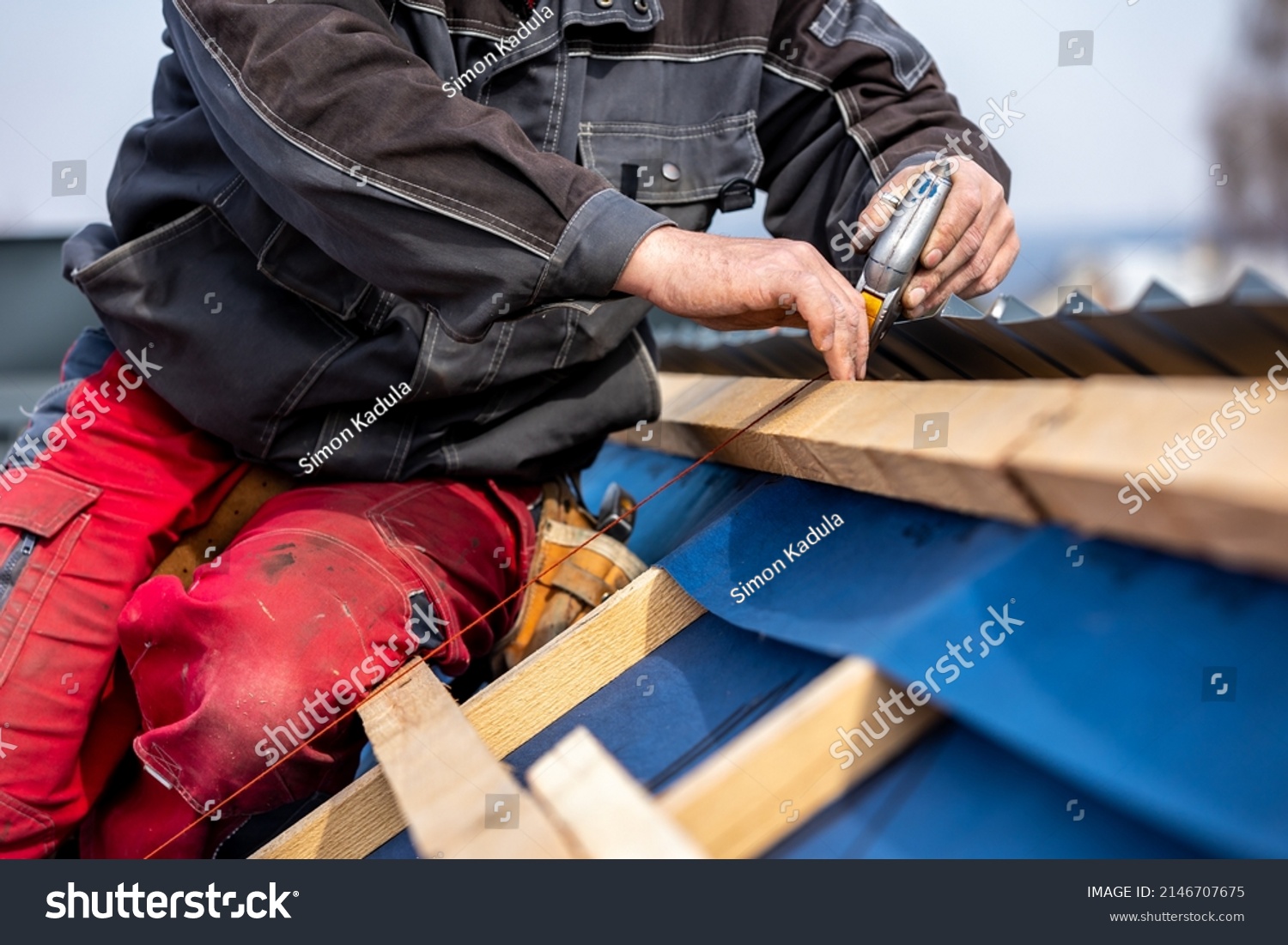 stock-photo-craftsman-or-construction-worker-install-a-new-roof-roofing-tools-new-metallic-roof-or-metal-2146707675