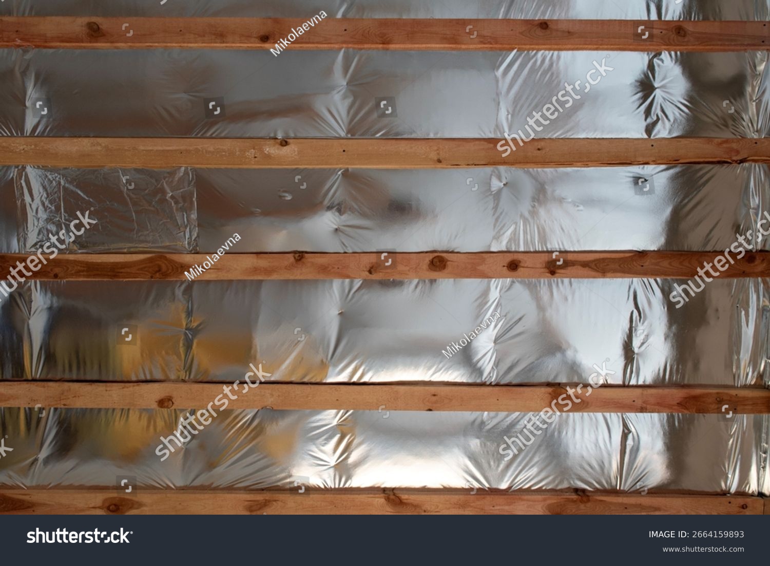 stock-photo-foil-insulation-on-wooden-battens-inside-an-unfinished-attic-ceiling-2664159893