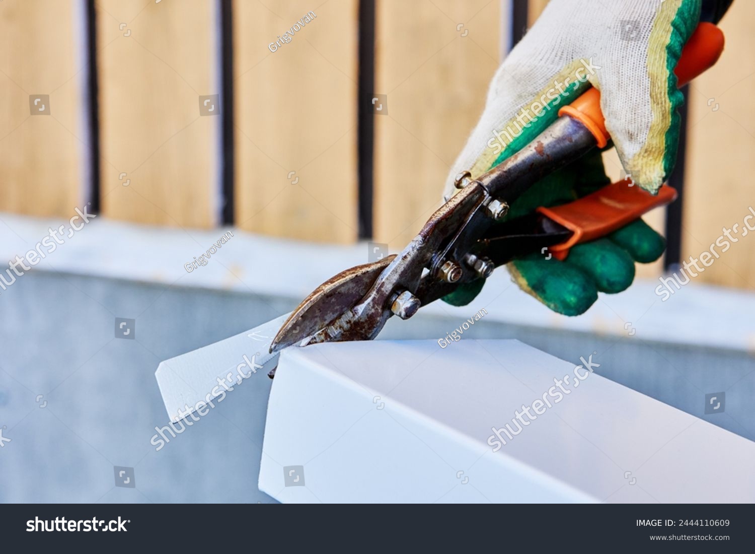 stock-photo-roofer-cuts-roofing-iron-with-sheet-metal-shears-2444110609