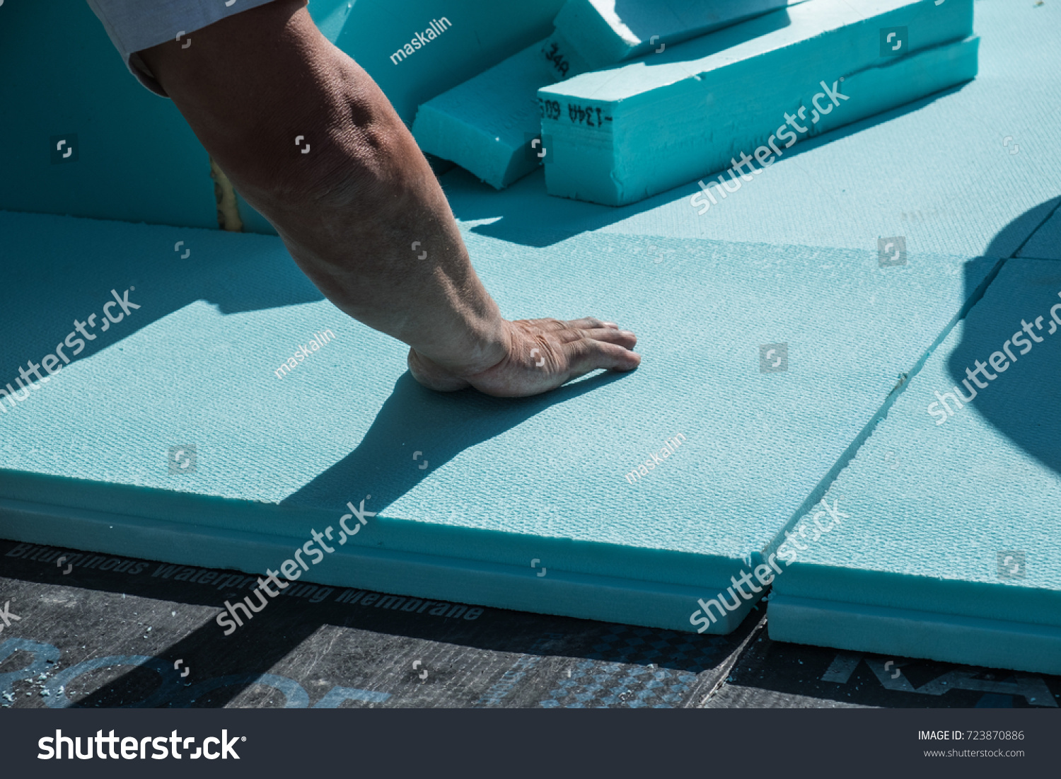 stock-photo-worker-placing-xps-polystyrene-insulation-boards-on-the-flat-roof-energy-saving-conceptual-723870886